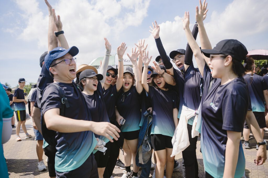 Đội chơi Team Building giơ tay ăn mừng sau khi hoàn thành thử thách Amazing Race trên bãi biển.